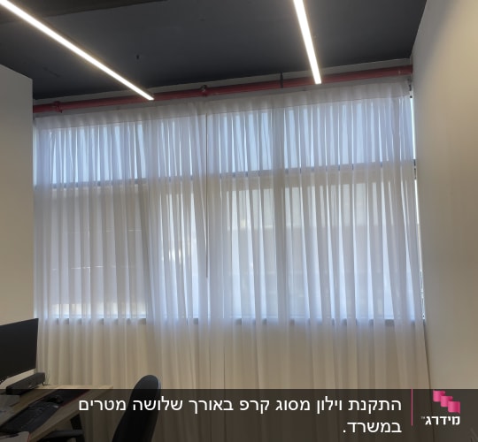 וילון לבן תלוי על חלון גדול במשרד